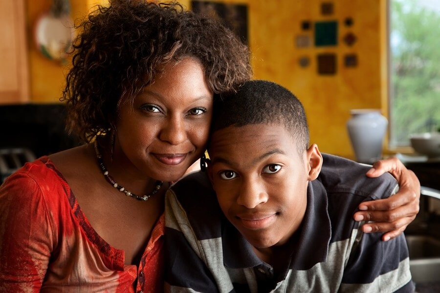 African American mom and son smiling in kitchen