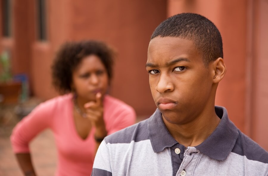 Angry teen with mother yelling in background