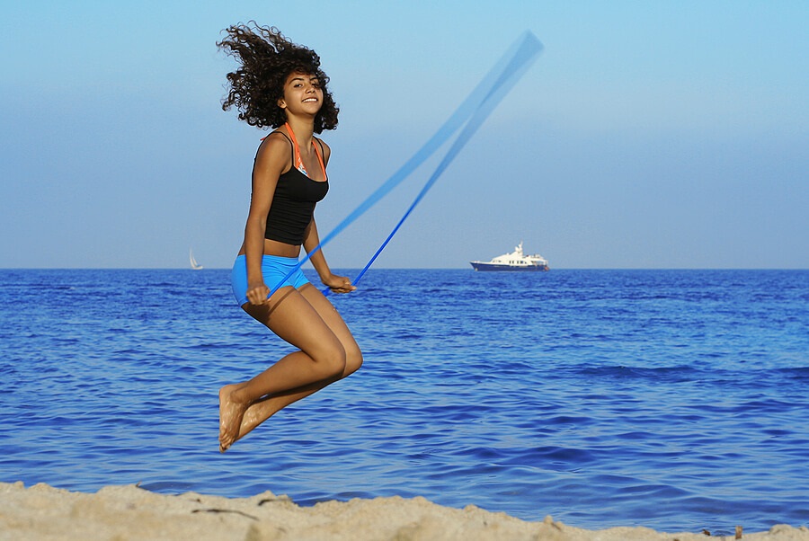 Fun Family Fitness, Teen girl jump roping on beach for exercise