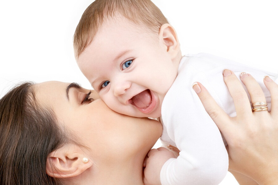 Mom kissing laughing baby