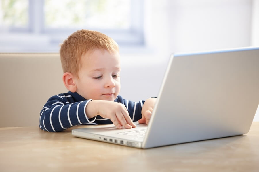 Young redheaded boy using laptop