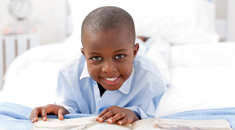 Boy reading book in bed