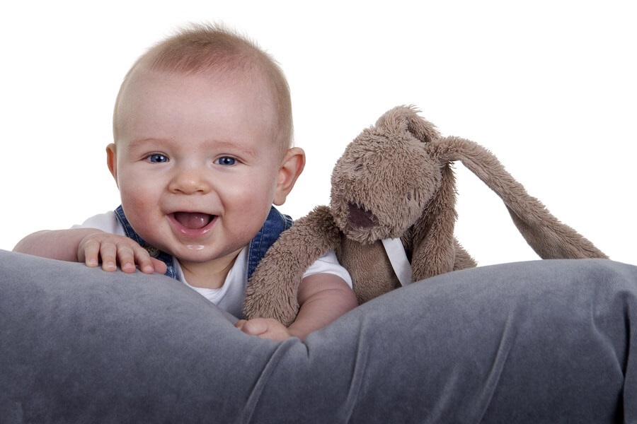 Baby on pillow with stuffed animal