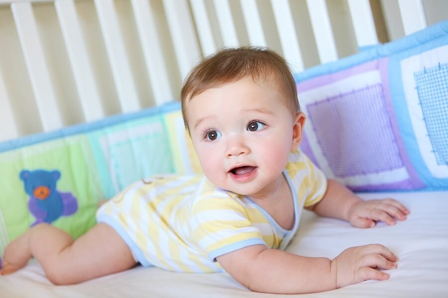 Baby boy having tummy time in crib