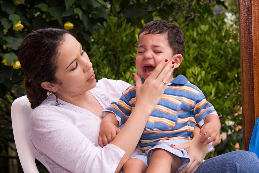 Crying boy sitting on mom's lap