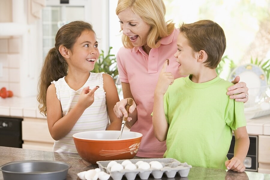 Mother and two children cooking in the kitchen.