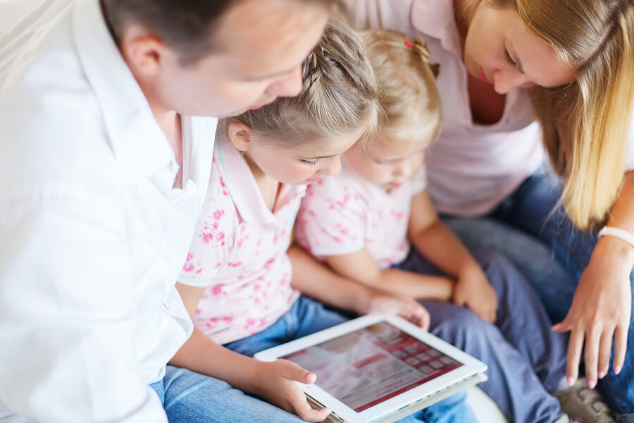 family sitting around tablet