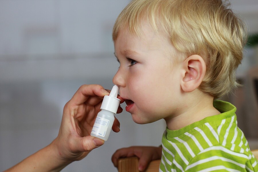 Little boy using nasal spray