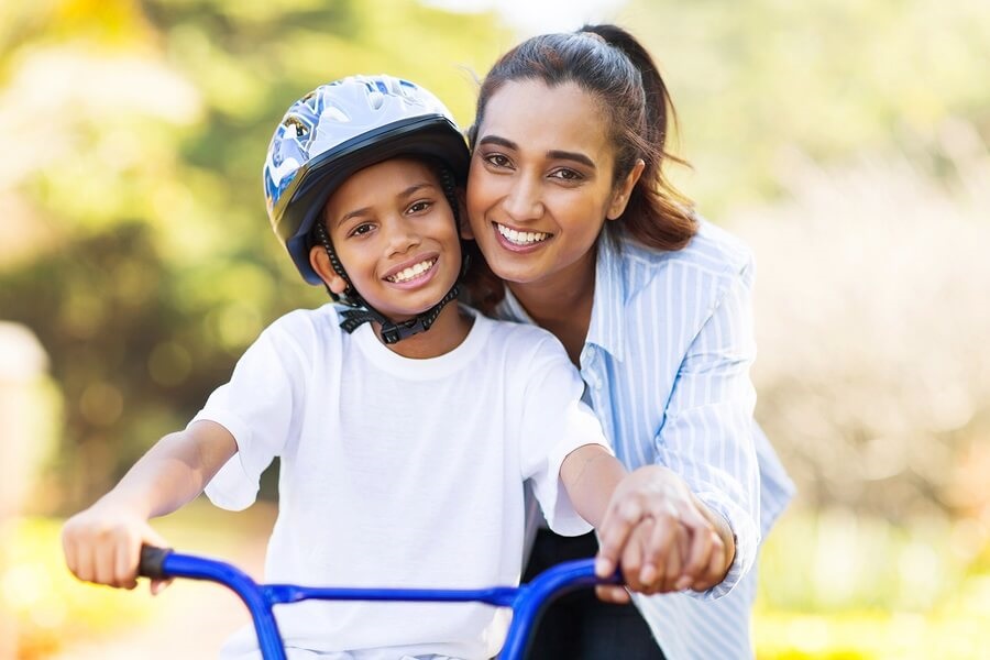 Smiling boy learning to ride bike