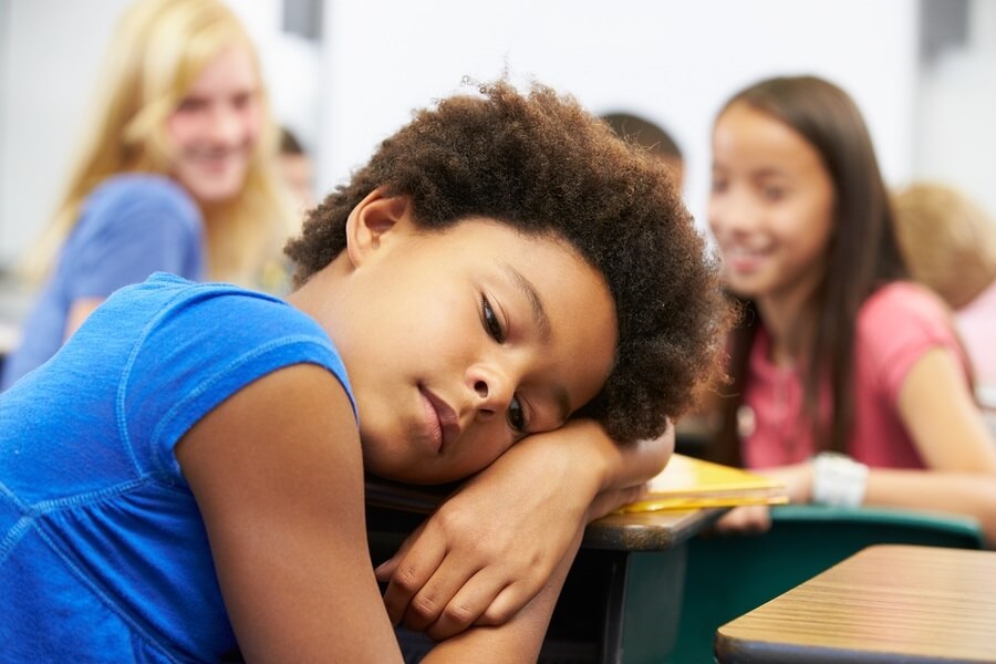 Unhappy girl being bullied in classroom