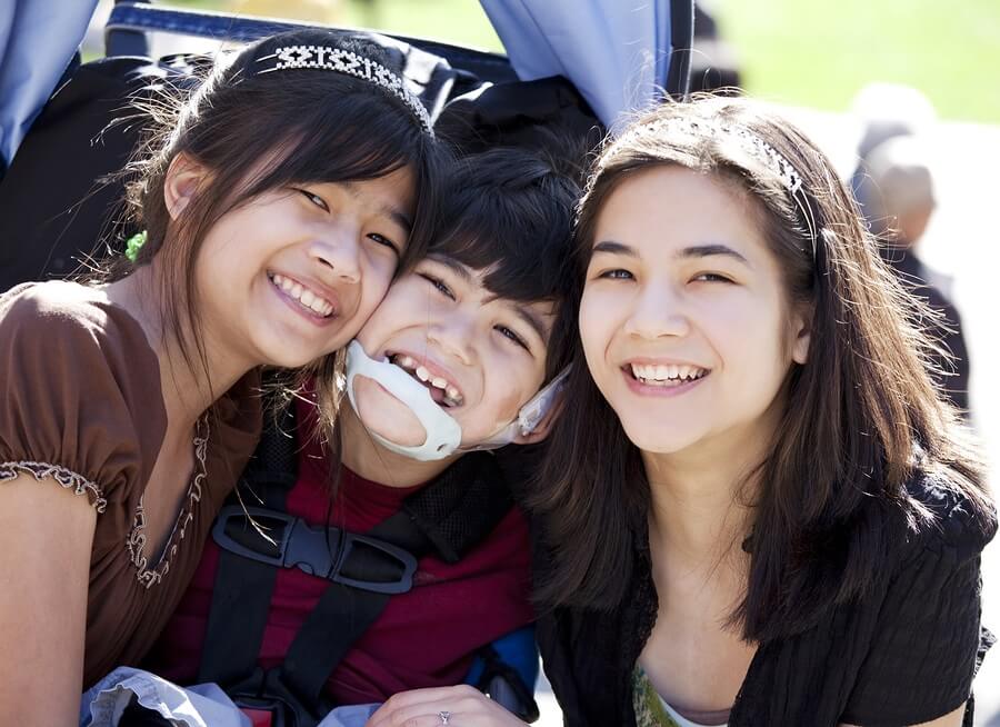 Two sisters with brother in wheelchair