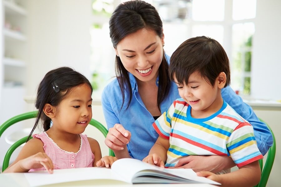 Mother helping son and daughter with homework.