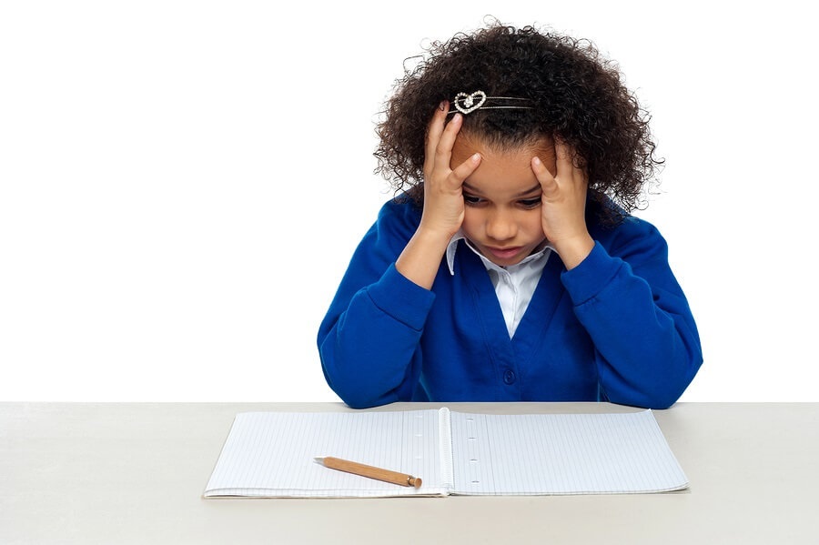 Stressed out student holding head in hands with pen.