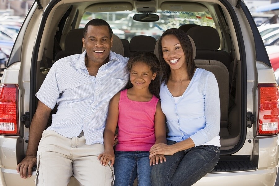 Happy family sitting in the back of family van