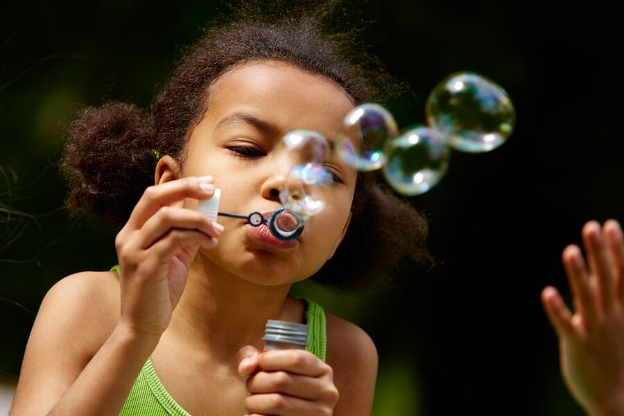 Little girl blowing bubbles