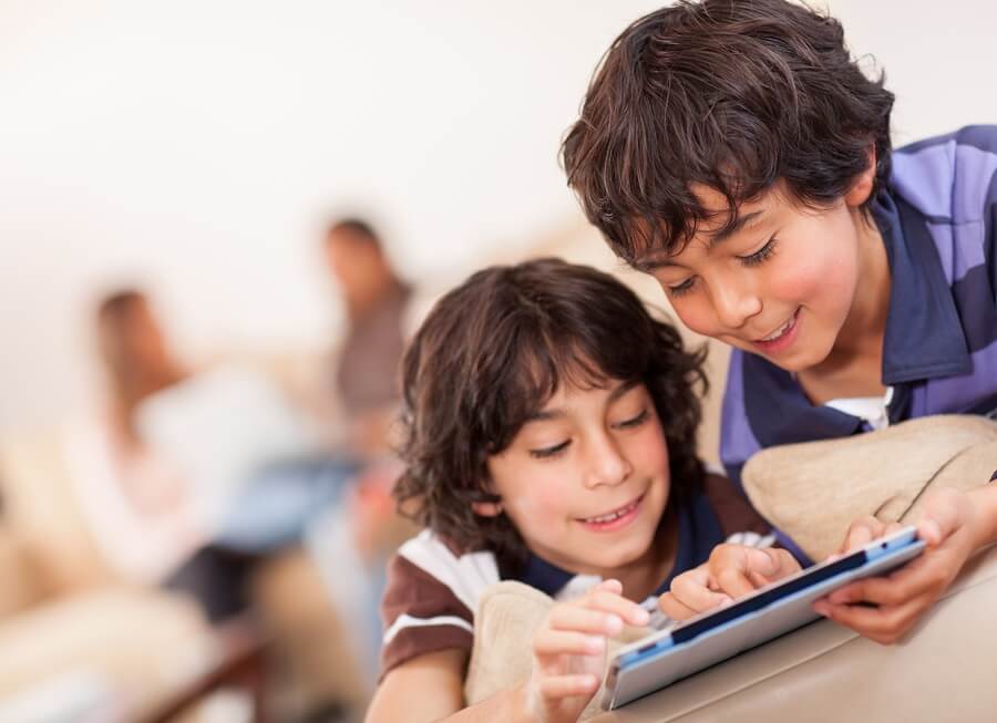 Two boys reading from a tablet