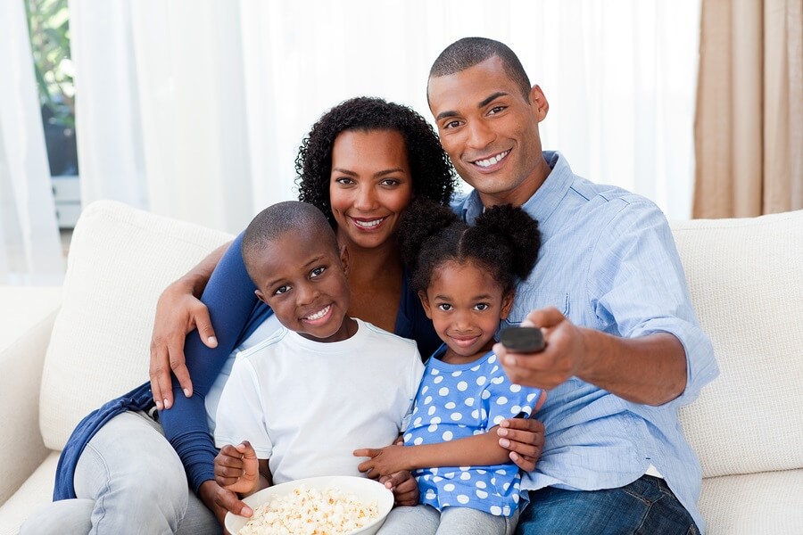 Happy family sitting on couch watching movie