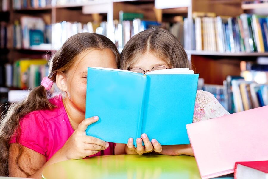 Two friend reading a book in library