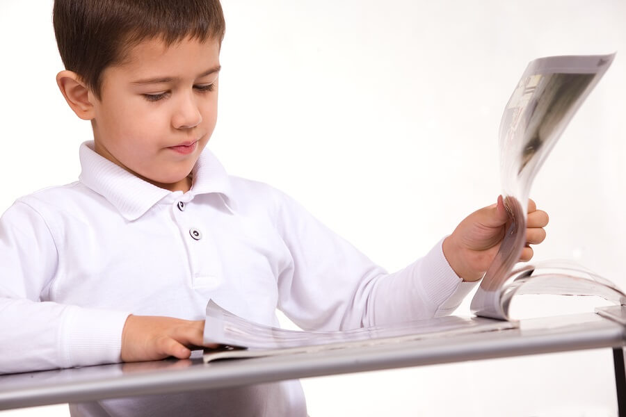 Young boy flipping through a magazine