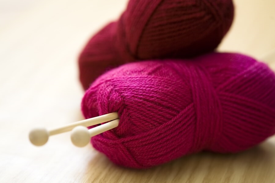 Two spools of red yarn piled on top of each other.