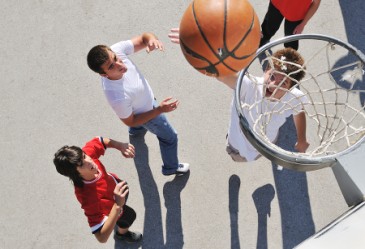 Groupd of teens playing a game of outdoor basketball