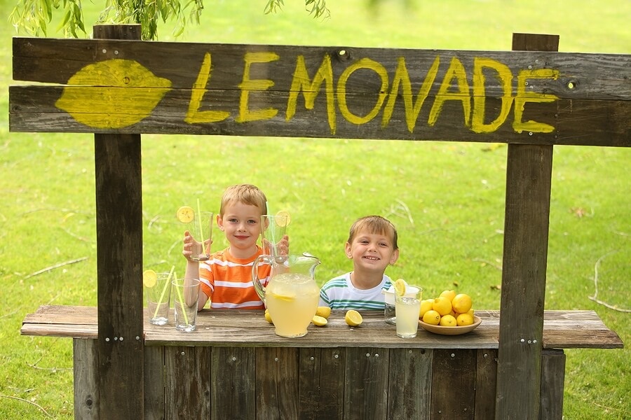 Two young kids running a lemonade stand