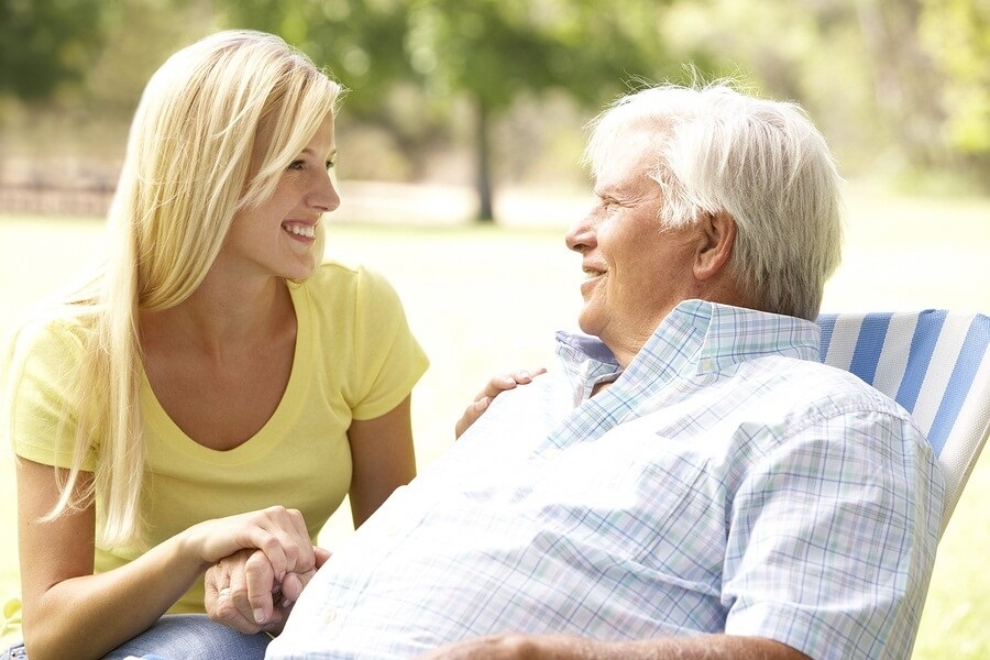 Adult daughter talking to her older father