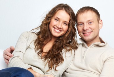 Smiling happy couple sitting down