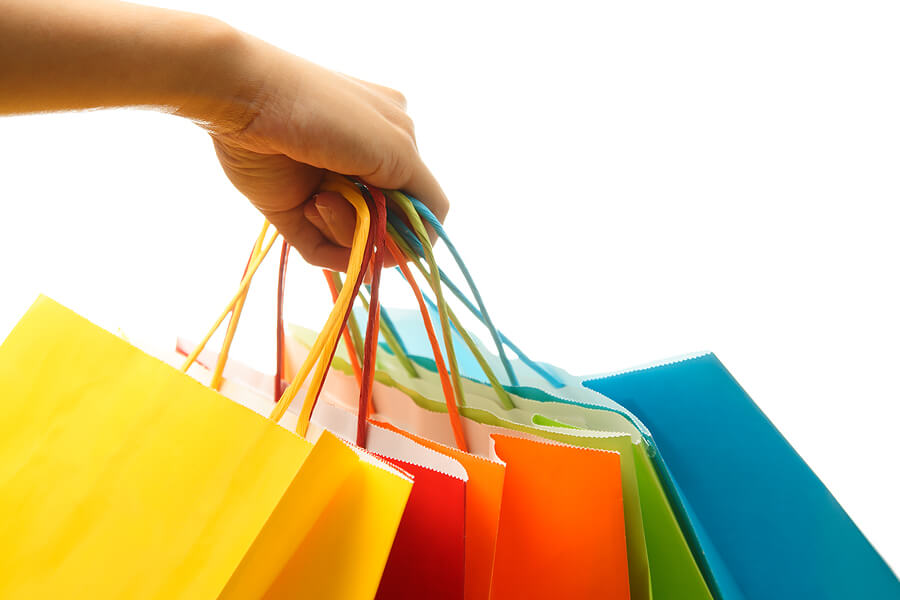 Woman holding handful of shopping bags