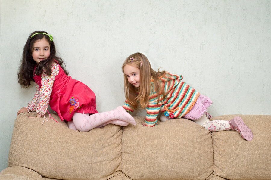 TwoGirlsPlaying,ClimbingonCouch