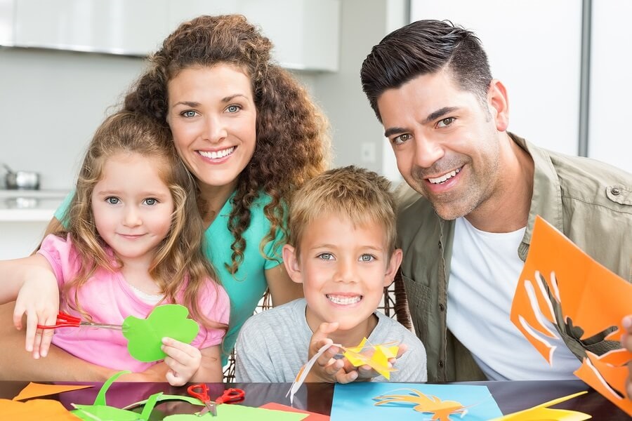 Family sitting at table doing arts and crafts