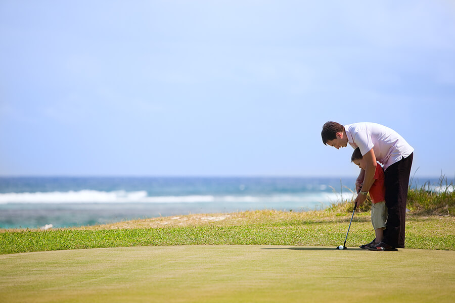 Fathers Day activities, father and young son golfing